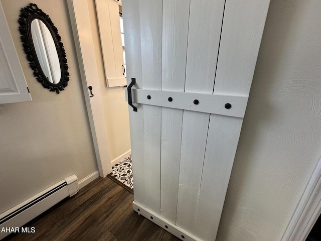 room details featuring a baseboard heating unit and wood-type flooring