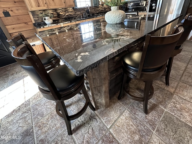 bar featuring dark stone counters and sink