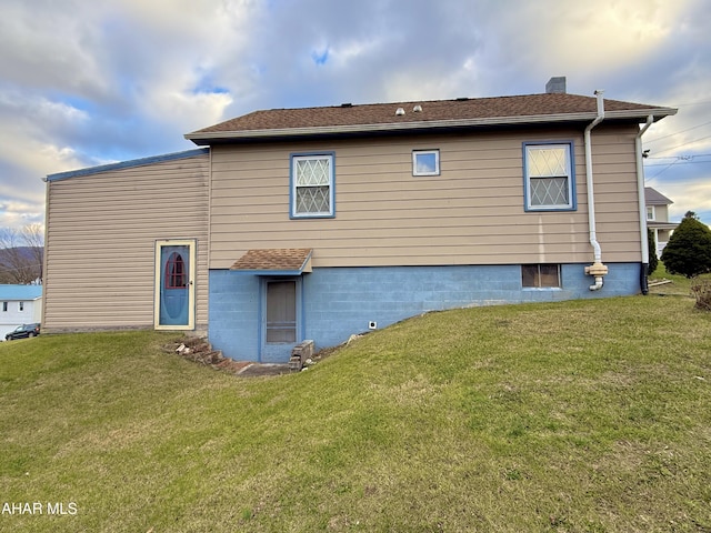 rear view of property featuring a yard