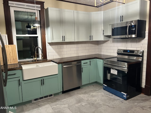 kitchen featuring decorative backsplash, sink, white cabinetry, and stainless steel appliances