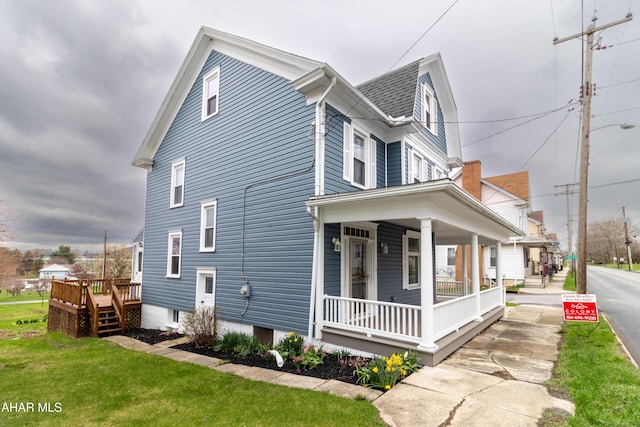 213 N Market St, Martinsburg, PA 16662 - view of property exterior with a lawn, a shingled roof, and covered porch