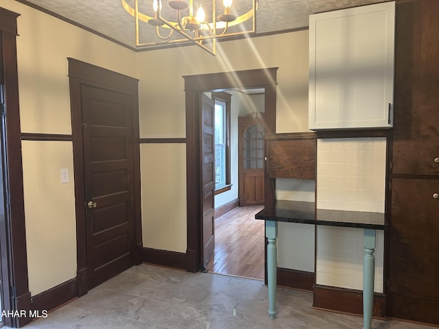 kitchen featuring white cabinets, decorative light fixtures, a chandelier, and light hardwood / wood-style flooring