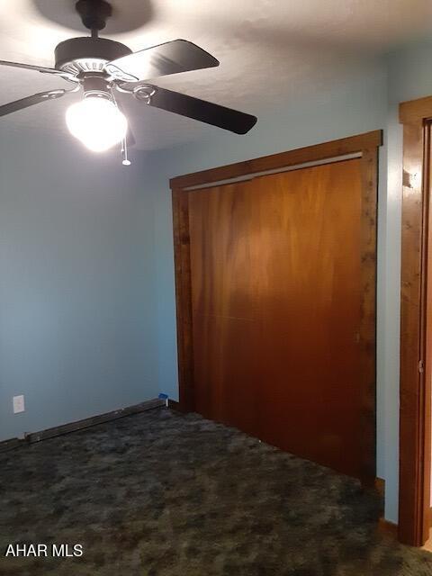 unfurnished bedroom featuring ceiling fan, carpet floors, and a closet