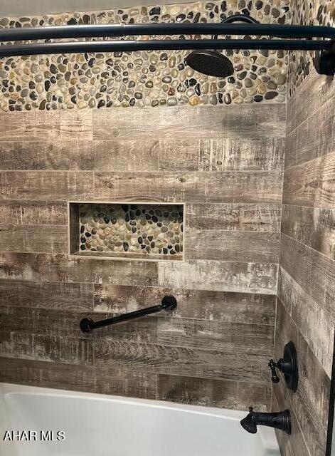 interior details featuring tiled shower / bath combo