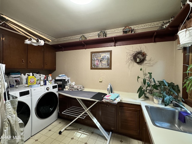 washroom featuring cabinets, sink, and washing machine and dryer