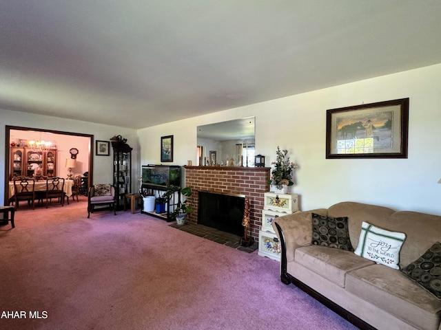 carpeted living room featuring a chandelier and a brick fireplace