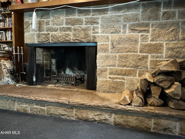 room details with a stone fireplace and carpet floors