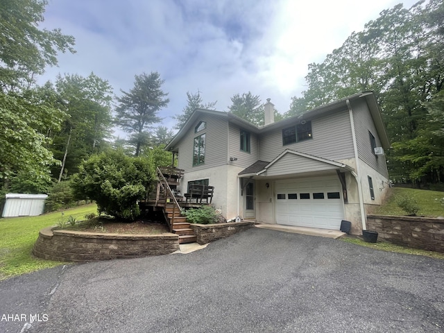 849-853 Fairview Rd, Howard, PA 16841 - view of front of property with stairs, asphalt driveway, a garage, a chimney, and a deck