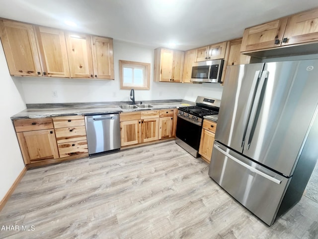 3100 Oak Ave, Altoona, PA 16601 - kitchen with stainless steel appliances, light brown cabinetry, baseboards, a sink, and light wood-style flooring