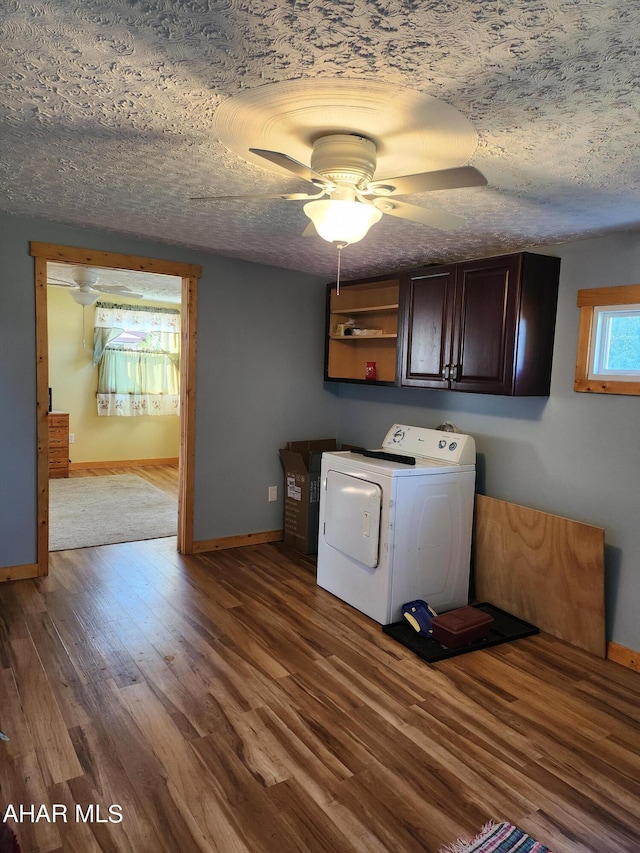 clothes washing area featuring ceiling fan, cabinets, dark hardwood / wood-style flooring, a textured ceiling, and washer / dryer