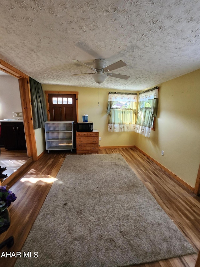 unfurnished bedroom with connected bathroom, wood-type flooring, and a textured ceiling