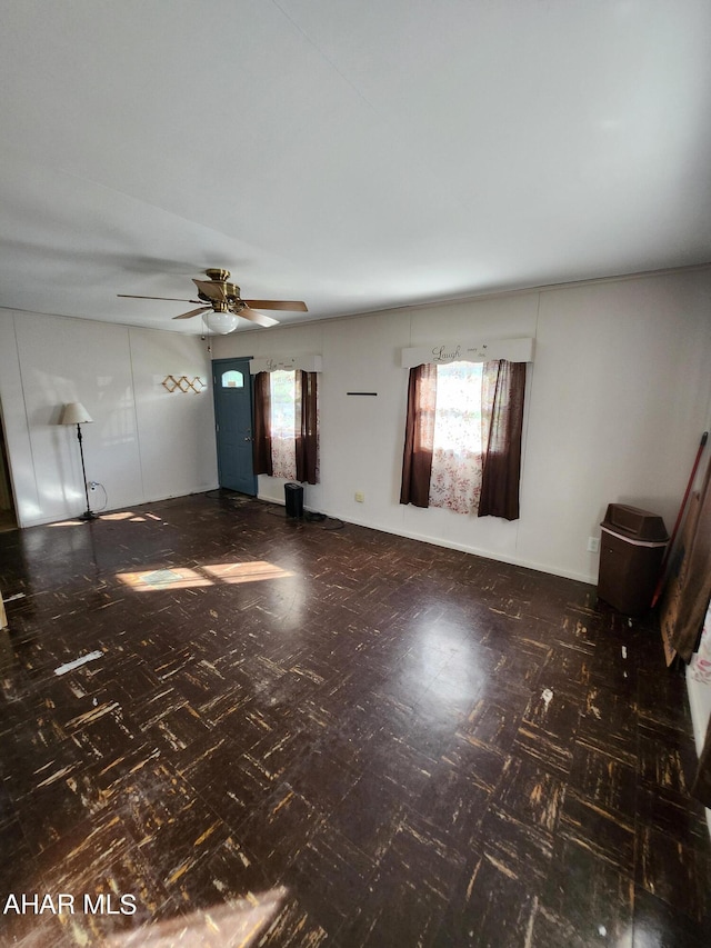 unfurnished living room with plenty of natural light and ceiling fan