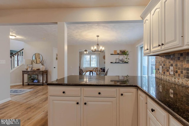 215 Oakwood Dr, Philipsburg, PA 16866 - kitchen featuring a peninsula, a healthy amount of sunlight, light wood-type flooring, a chandelier, and backsplash