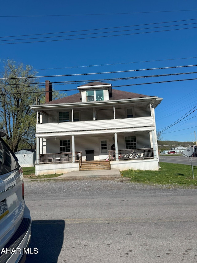 traditional style home featuring covered porch and a chimney
