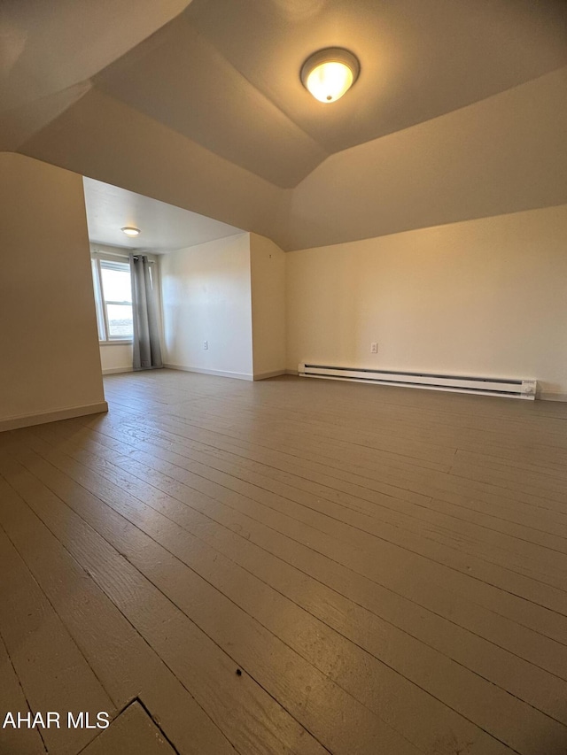 interior space featuring a baseboard heating unit, baseboards, vaulted ceiling, and hardwood / wood-style flooring