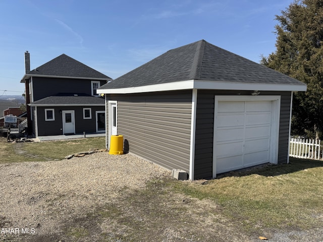 detached garage featuring fence