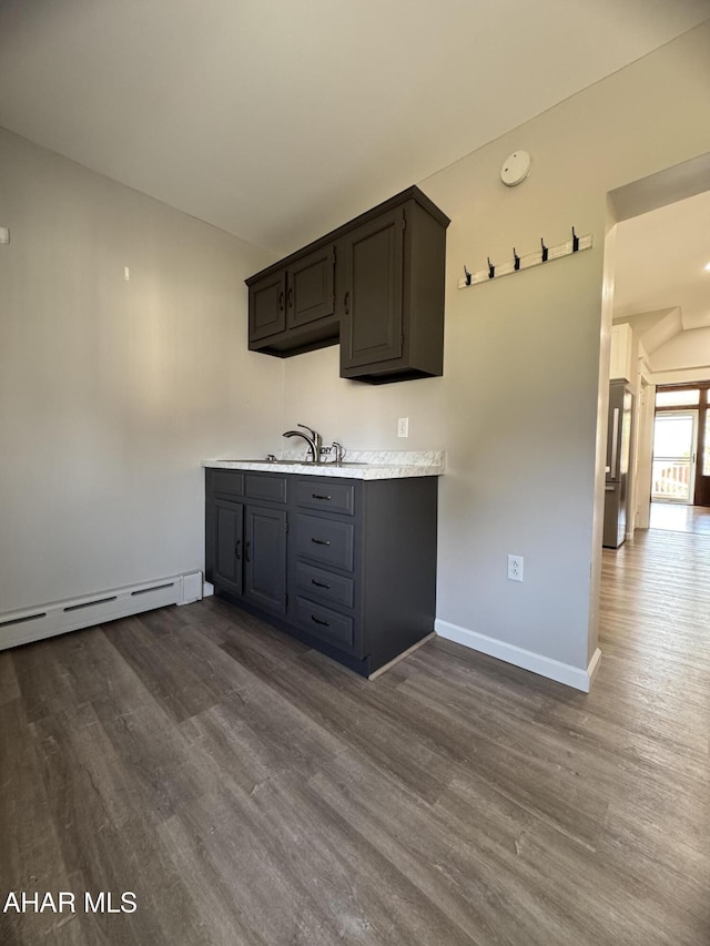 kitchen with light countertops, dark wood-type flooring, and a baseboard radiator