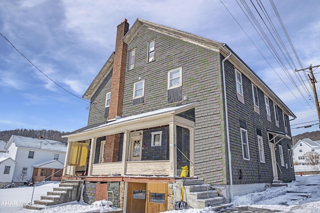 view of front of property featuring a chimney and a porch