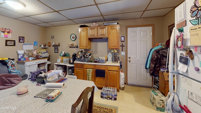 kitchen featuring light countertops, a sink, and a drop ceiling