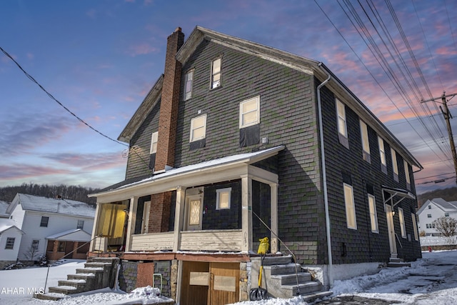 view of front of home featuring a porch and a chimney