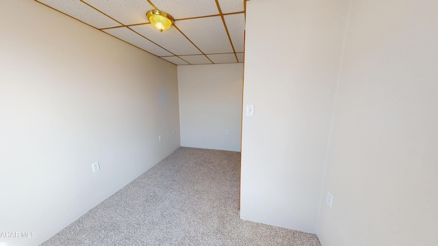 carpeted empty room with a drop ceiling