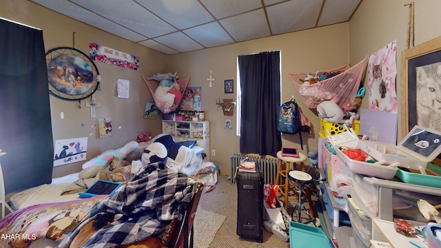 carpeted bedroom with a paneled ceiling