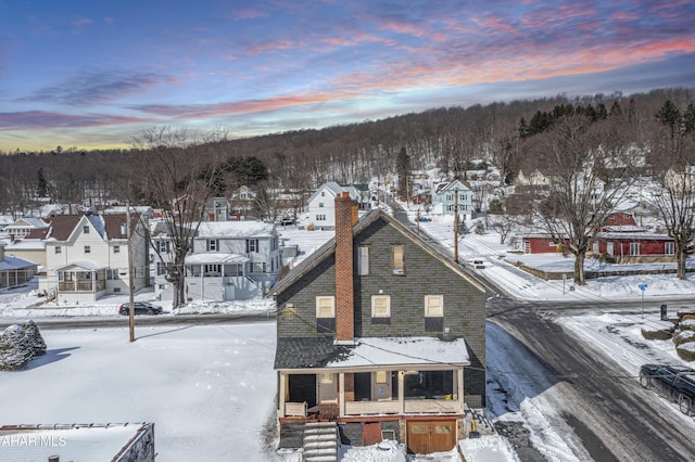 snowy aerial view with a residential view