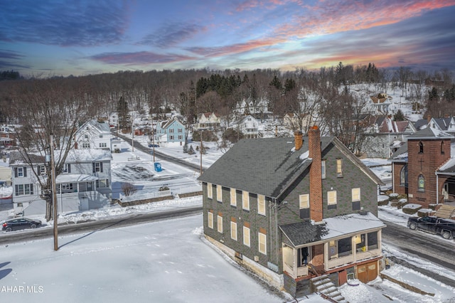 snowy aerial view with a residential view