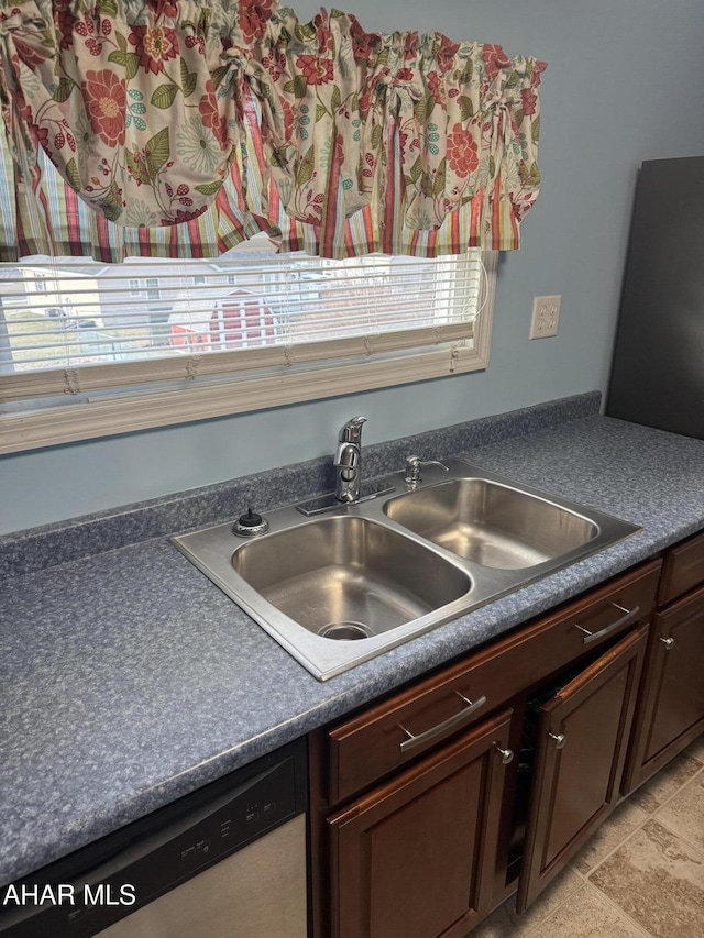 kitchen with dark brown cabinets, sink, and dishwashing machine