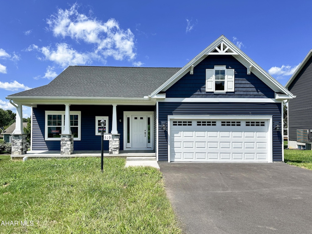 craftsman-style house with a porch, a garage, and a front yard