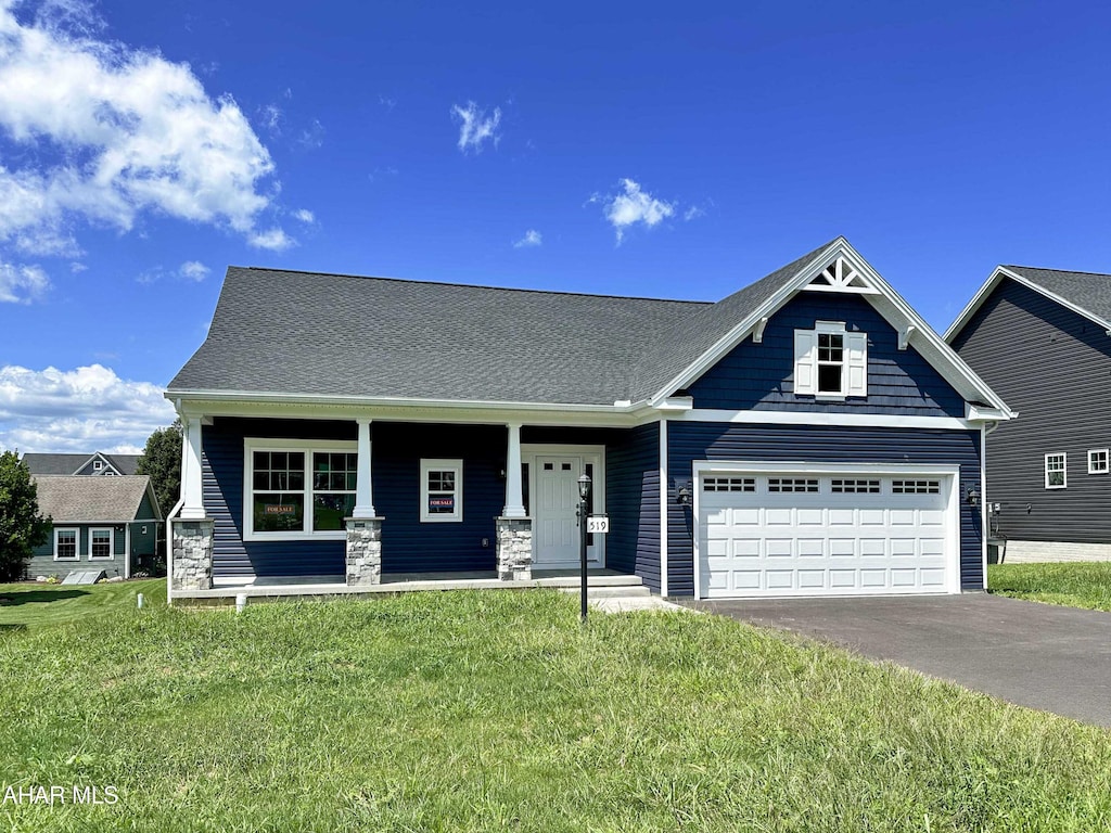 craftsman house with covered porch, a garage, and a front lawn