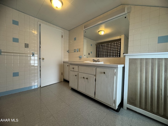 bathroom featuring sink and tile walls