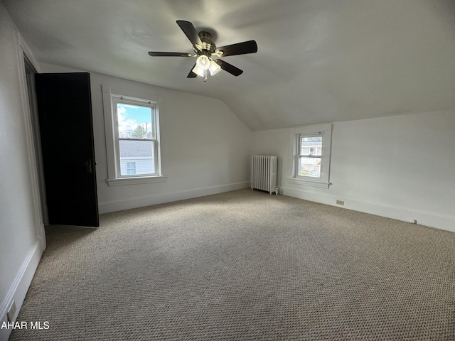 bonus room with lofted ceiling, ceiling fan, radiator heating unit, and light carpet