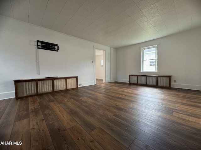 unfurnished room with dark hardwood / wood-style flooring and radiator