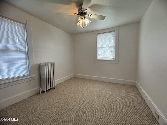 carpeted spare room with radiator heating unit and ceiling fan