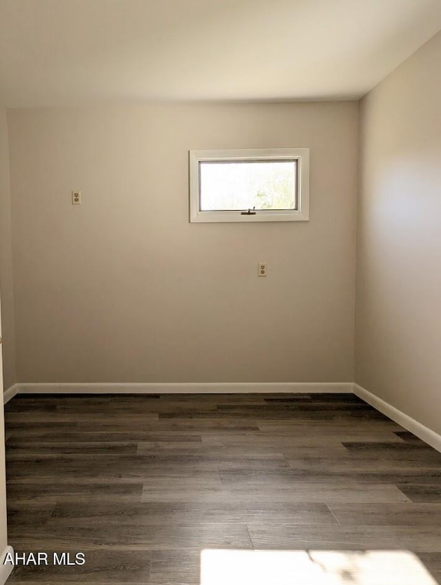 spare room with dark hardwood / wood-style flooring