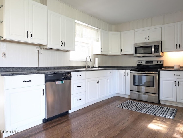 kitchen with white cabinets, sink, dark hardwood / wood-style flooring, and stainless steel appliances