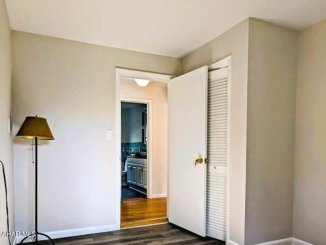 unfurnished bedroom featuring a closet and dark wood-type flooring