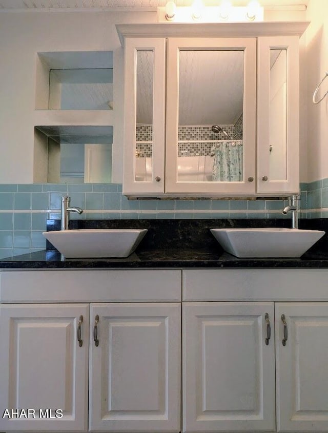 kitchen featuring white cabinets, sink, and tasteful backsplash