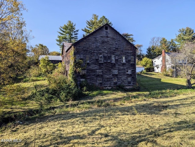 view of property exterior with a lawn