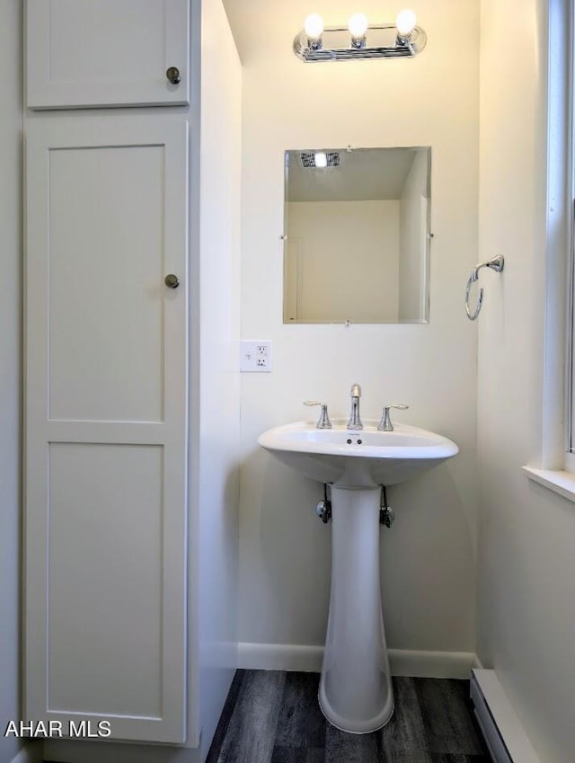 bathroom with hardwood / wood-style flooring and a baseboard heating unit