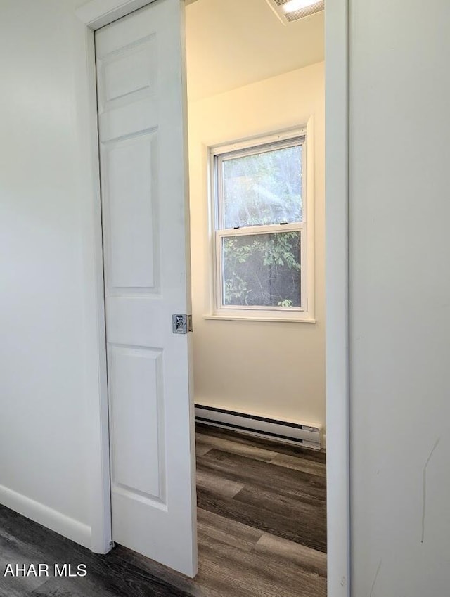 hall with dark wood-type flooring and a baseboard radiator