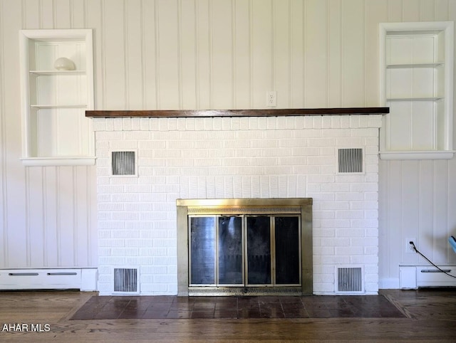 room details featuring hardwood / wood-style flooring, a fireplace, and a baseboard heating unit