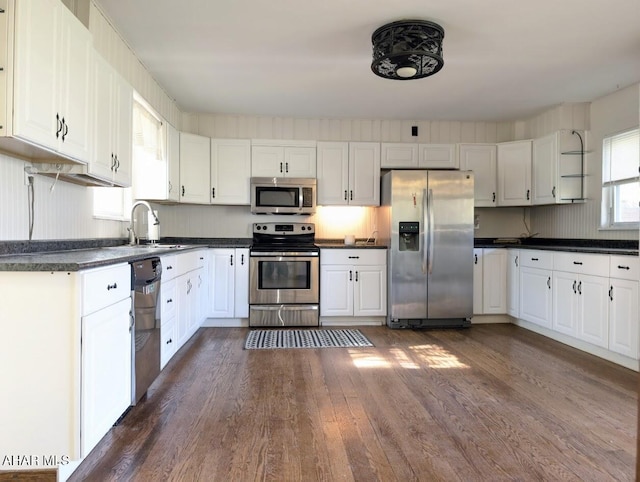 kitchen with white cabinetry, sink, stainless steel appliances, and dark hardwood / wood-style floors