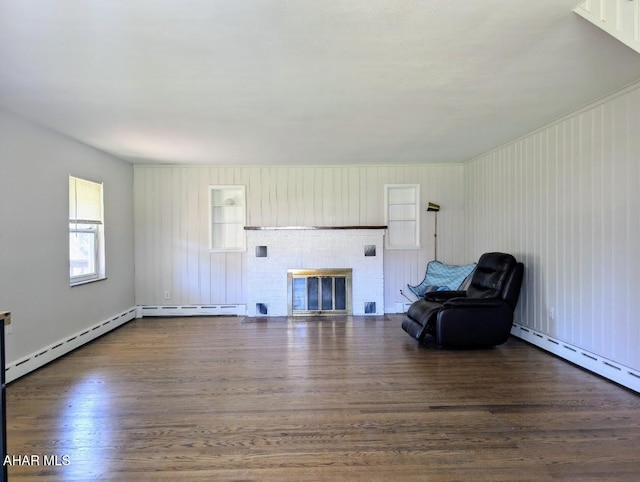 unfurnished room with dark hardwood / wood-style floors, baseboard heating, and a brick fireplace