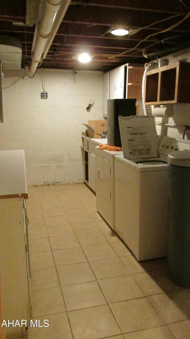 washroom with light tile patterned flooring and washer and dryer