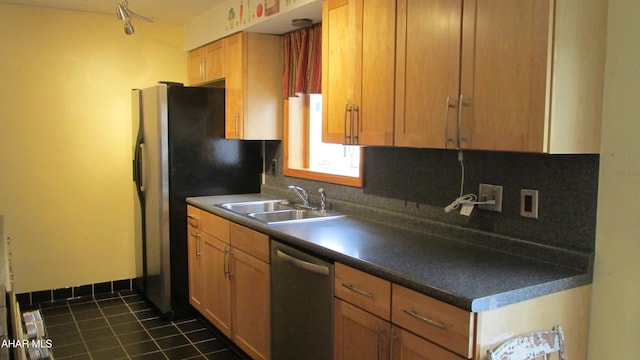 kitchen with sink, dark tile patterned floors, dishwasher, and backsplash