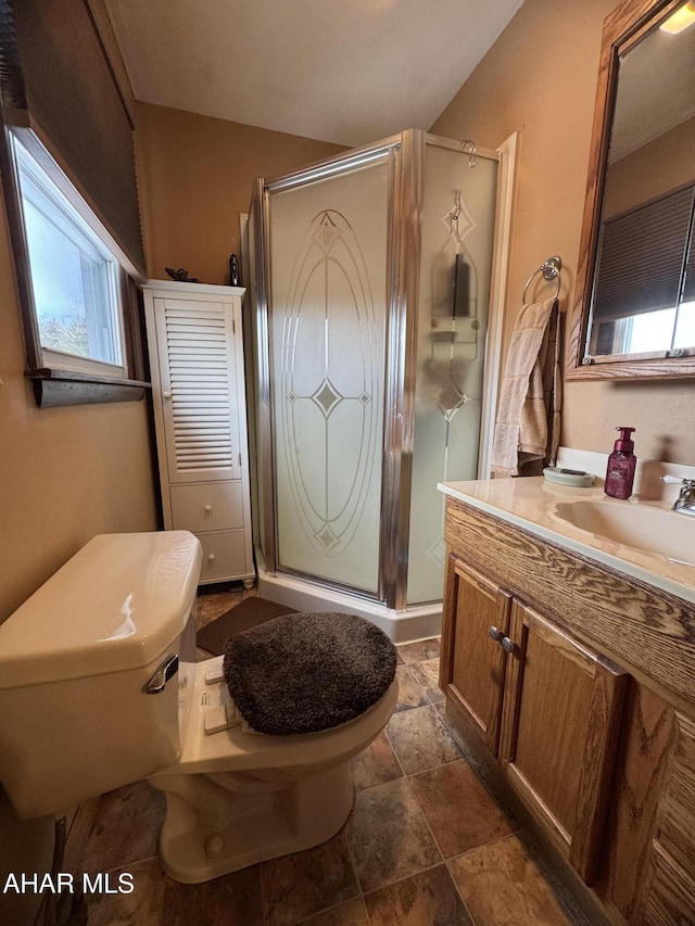 bathroom featuring walk in shower, vanity, and toilet