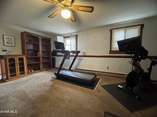 workout room featuring ceiling fan, a baseboard radiator, and carpet