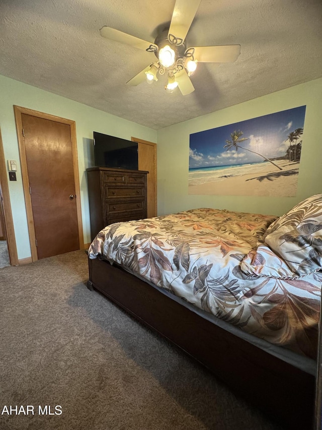 carpeted bedroom with ceiling fan and a textured ceiling